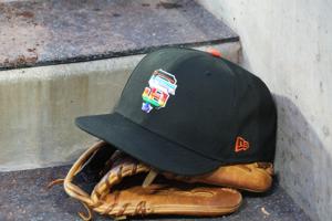 A rainbow colored San Francisco Giants logo cap and a glove in the dugout during LGBTQ+ Pride Night at Dodger Stadium at Dodger Stadium on Jun 16, 2023.