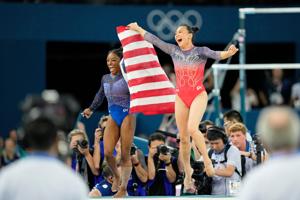 Simone Biles and Sunisa Lee of the United States celebrate after winning gold and bronze in the women’s gymnastics all-around during the Paris 2024 Olympic Summer Games at Bercy Arena.