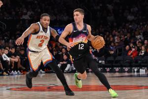 Phoenix Suns guard Collin Gillespie (12) dribbles past New York Knicks guard Miles McBride (2) during the second half at Madison Square Garden in New York, on Jan. 17, 2026.