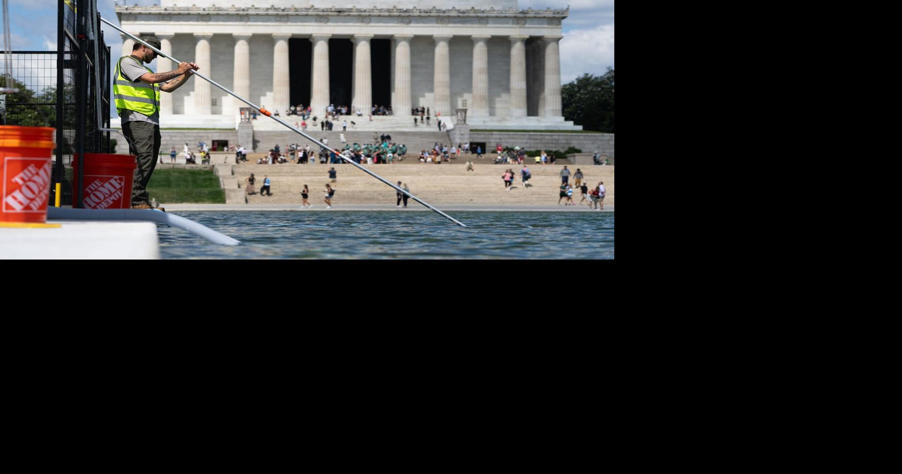 Crews are pictured clearing up algae that began to grow in the Reflecting Pool on June 15, 2026