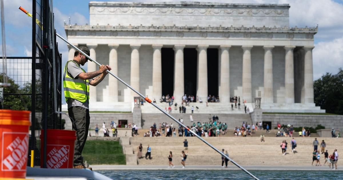 Crews are pictured clearing up algae that began to grow in the Reflecting Pool on June 15, 2026