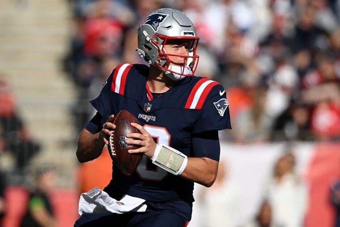 New England Patriots fans hold a signs welcoming back quarterback