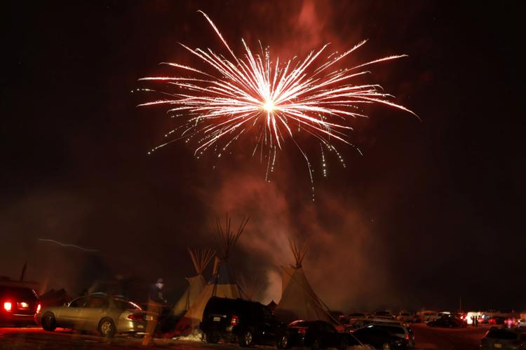 Fireworks explode above tipis inside of the Oceti Sakowin camp