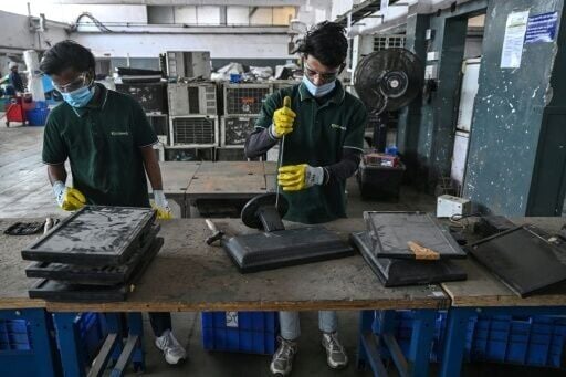 Workers dismantle discarded monitors at 'Ecowork', an e-waste recycling facility in Ghaziabad, India