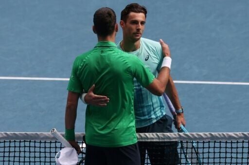 Serbia’s Novak Djokovic (L) embraces Italy’s Lorenzo Musetti