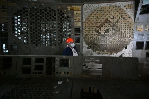 An employee of the Chernobyl Nuclear Power Plant walks in the control room of the destroyed 4th block of the plant