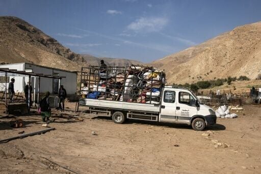Men help load belongings onto a truck as a Bedouin family leave their home in the West Bank