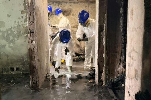 Hong Kong Police Force handout photo released shows officers inside the charred Wang Fuk Court residential estate