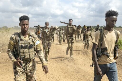 Soldiers of the Somali National Army (SNA) walk near the front line
