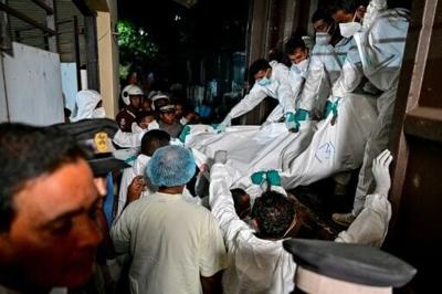 Sri Lankan healthcare workers carry the bodies of Iranian sailors who died in the US torpedo attack