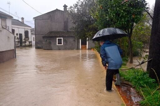 A man crosses a flooded street in Jimera de Libar, southern Spain, on February 4, 2026 amid Storm Leonardo