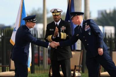 Chairman of the Joint Chiefs of Staff General Dan Caine (L) shakes hands with Air Force Lieutenant General Evan Pettus (R) as Navy Admiral Alvin Holsey (C) looks on at US Southern Command headquarters on in Doral, Florida on December 12, 2025