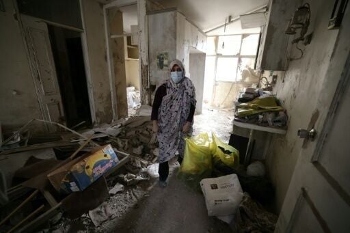 An Iranian woman collects belongings from her destroyed home following a military strike on Tehran on March 15