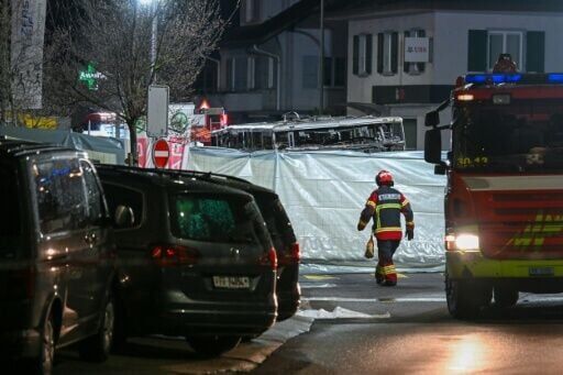 Tarpaulins were set up around the burnt-out shell of the passenger bus