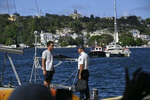 A crew member (L) of one of the two sailboats that were transporting humanitarian aid speaks with a Cuban Border Guard Troops officer upon its arrival in Havana