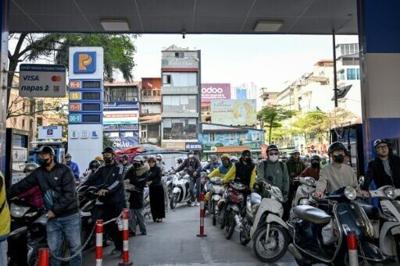 Motorists queue to pump gasoline into their vehicle at a gas station in Hanoi on March 10, 2026