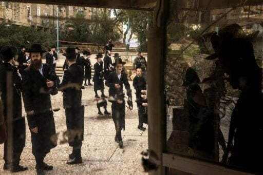 Israeli Orthodox Jews inspect the site of an Iranian missile strike in Arad on March 22