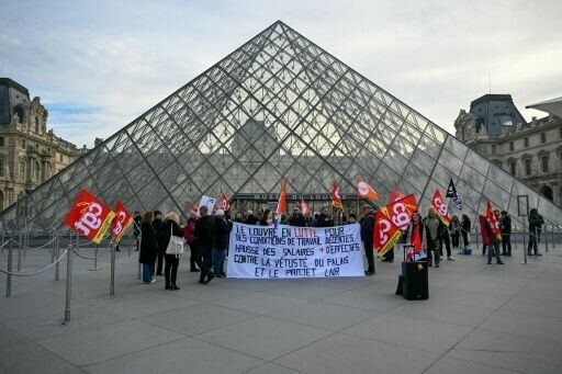 Staff gather outside the main entrance to Louvre after a staff meeting to vote in favour of strike action