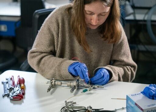 A scientist works on equipment used for taking samples from the maritime environemnt