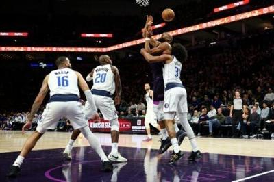 Minnesota Timberwolves center Rudy Gobert and Marvin Bagley III of the Dallas Mavericks tangle under the basket in an NBA game