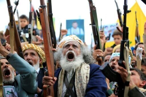 Supporters of the Iran-backed Houthi movement brandish their weapons as they rally in solidarity with Iran and Lebanon