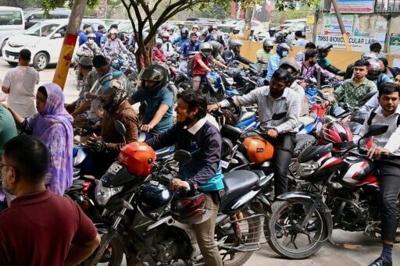 People queue up to refuel their motorbikes at a gas station in Dhaka. Around seven million Bangladeshis work overseas -- the majority in the Middle East, with Saudi Arabia hosting around two-thirds of the total
