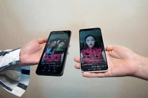 This photo illustration taken in Hong Kong shows phones displaying screenshots of a video from Chinese model and influencer Christine Li accusing an AI microdrama of stealing her likeness without consent