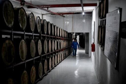 A worker walks past barrels used for maturing beverages at Murree Brewery in Rawalpindi