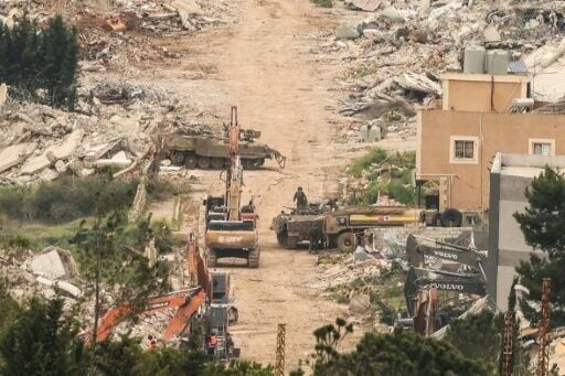 From the Israeli side of the border with Lebanon Israeli army armoured vehicles and excavators are visible among destroyed buildings
