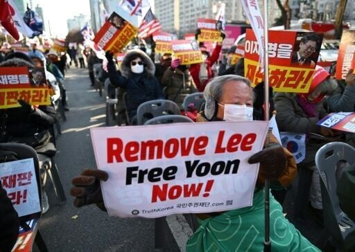 Supporters of South Korea's ousted president Yoon Suk Yeol hold a placard reading "Remove Lee, Free Yoon now!"