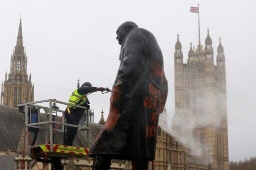 A worker used a pressure hose to clean the graffiti off the statue of Winston Churchill