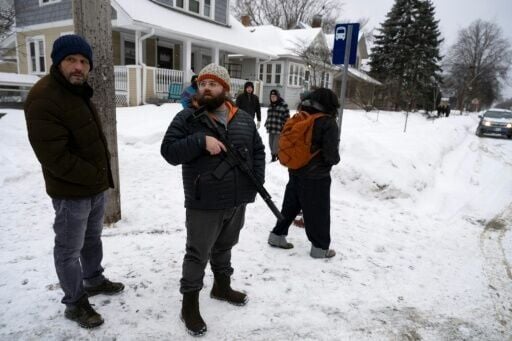 A resident of Falcon Heights, Minnesota, holds an AR-15 semi-automatic rifle in public after he and other neighbors spotted what they believed to be agents of the US Immigration and Customs Enforcement, which has led a mass crackdown on immigrants