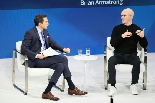 Coinbase CEO Brian Armstrong (R) speaks during a New York Times event in December 2025