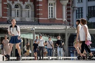 People walk past Tokyo Station on a hot day in Tokyo in 2025. This year city authorities are encouraging staff to wear shorts to work to cut reliance on air conditioning
