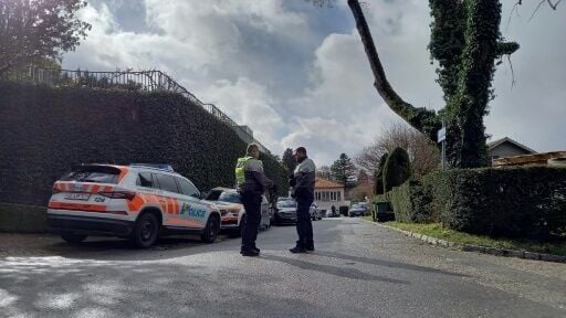 Police officers stand guard at the end of the private street leading to the Omani ambassador's residence