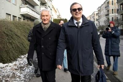 Norway's former prime minister Thorbjorn Jagland (L) and his lawyer (R) put on smiles as they left one of the premises being searched