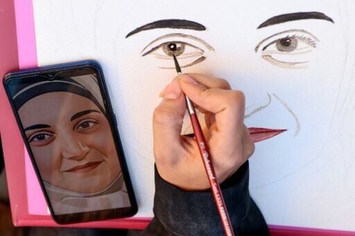 A protester draws a portrait of Mahdieh Esfandiari, an Iranian woman who was handed one year in prison for justifying terrorism in France