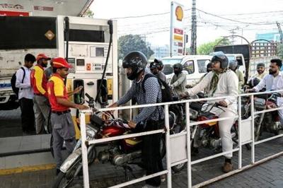 People queue to refuel their vehicles at a filling station in the Pakistani city of Lahore in March 2026 -- prices are now set to rise significantly