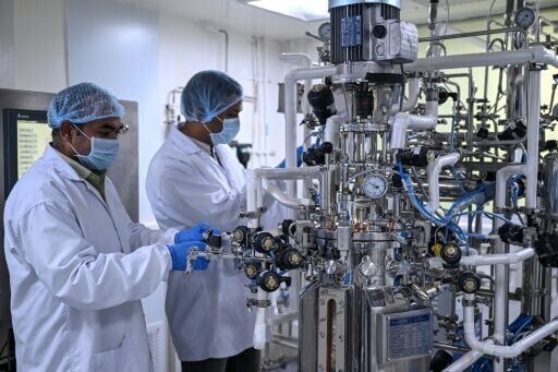 Researchers checking on a fermenter machine at a vaccine laboratory in New Delhi