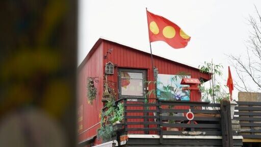 A Christiania flag flutters outside a building in Copenhagen's libertarian enclave