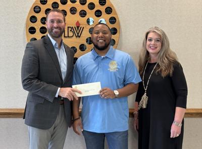 Robert Stewart gives grant check to Lurleen Wallace Community College