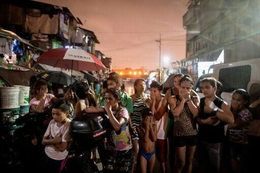 Residents near a crime scene on September 28, 2016 where three alleged drug dealer were killed after a drug raid in a shanty community in Manila