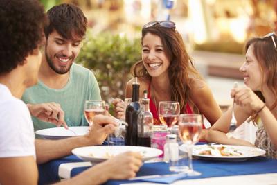 Young Friends Enjoying Meal In Outdoor Restaurant