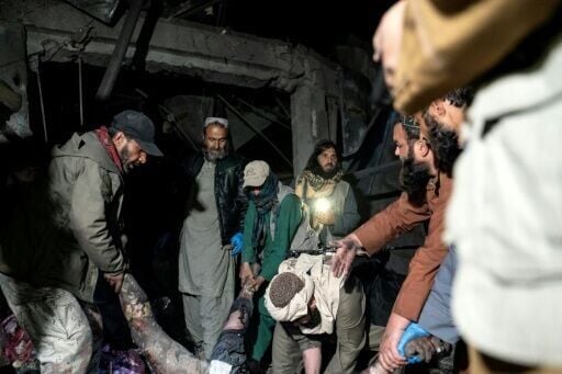 Afghan rescue teams and Taliban security personnel carrying a victim's body following Pakistani airstrikes on a drug rehabilitation centre in Kabul