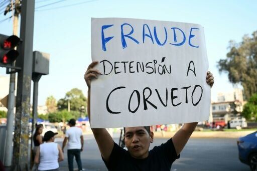 A man in Lima holds a banner outside of Peru’s National Office of Electoral Processes that reads 'Fraud, arrest Corvetto' (referring to its chief, Piero Corvetto)