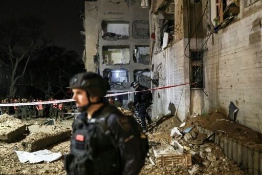 First responders inspect the site of an Iranian missile strike in Arad