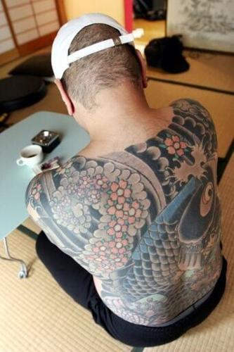 Written on the skin: a retired yakuza crime boss shows his tattoo of a carp swimming up a waterfall