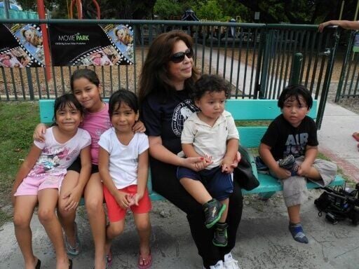 Pictured in 2009, Nora Sandigo (C) sits with five of the children she has had guardianship over, in her career supporting immigrant families