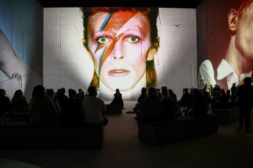 People attend the multimedia show 'David Bowie: You're Not Alone', showcasing work from the British musical legend, at the Lightroom venue in Kings Cross in London