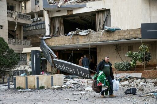 A man leaves the Comfort Hotel in Lebanon after it was hit by an air strike